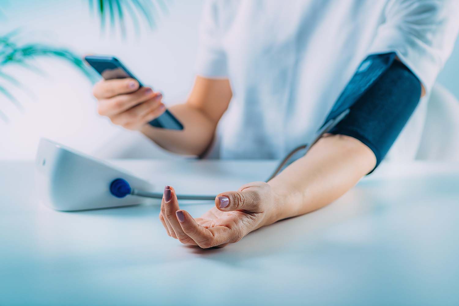 Woman measuring her own blood pressure using phone